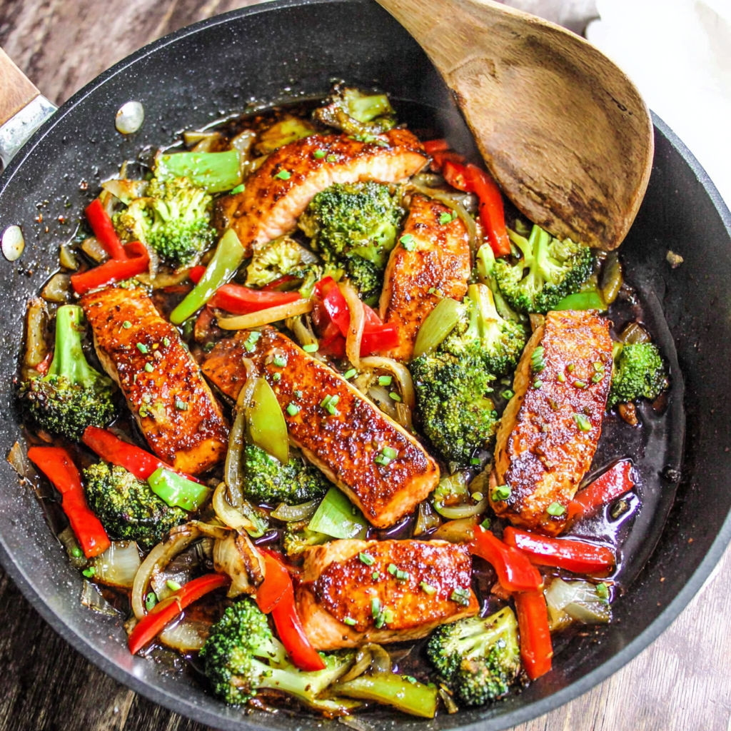 A pan of food with broccoli and red peppers.