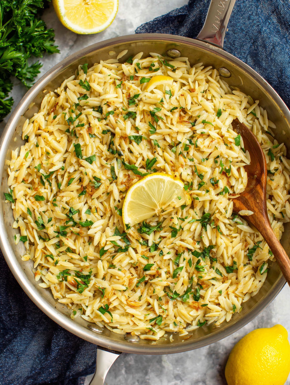 A bowl of rice with lemon and herbs.