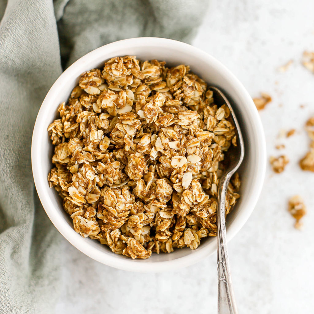 A bowl of granola with a spoon in it.