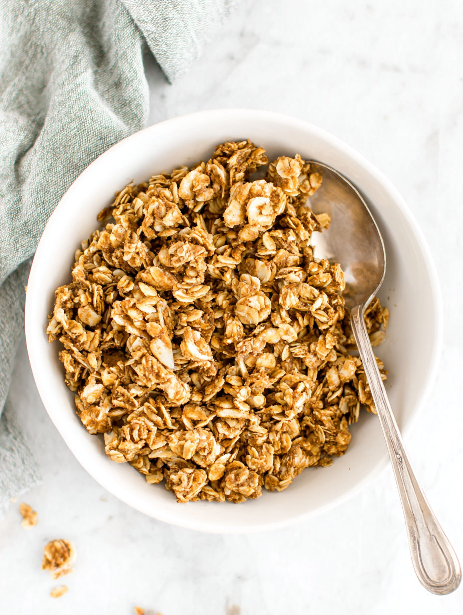 A bowl of granola with a spoon in it.
