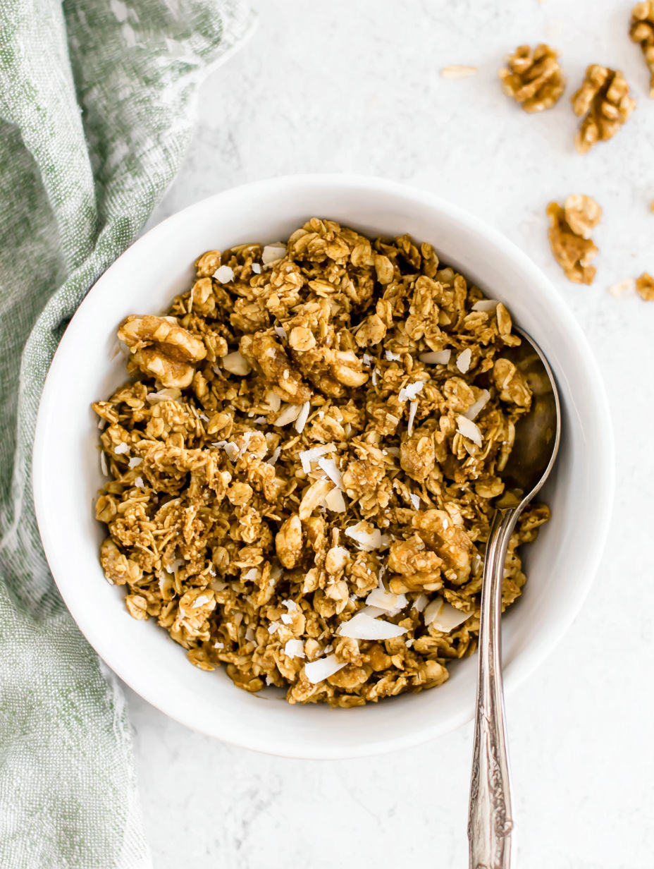 A bowl of granola with a spoon in it.