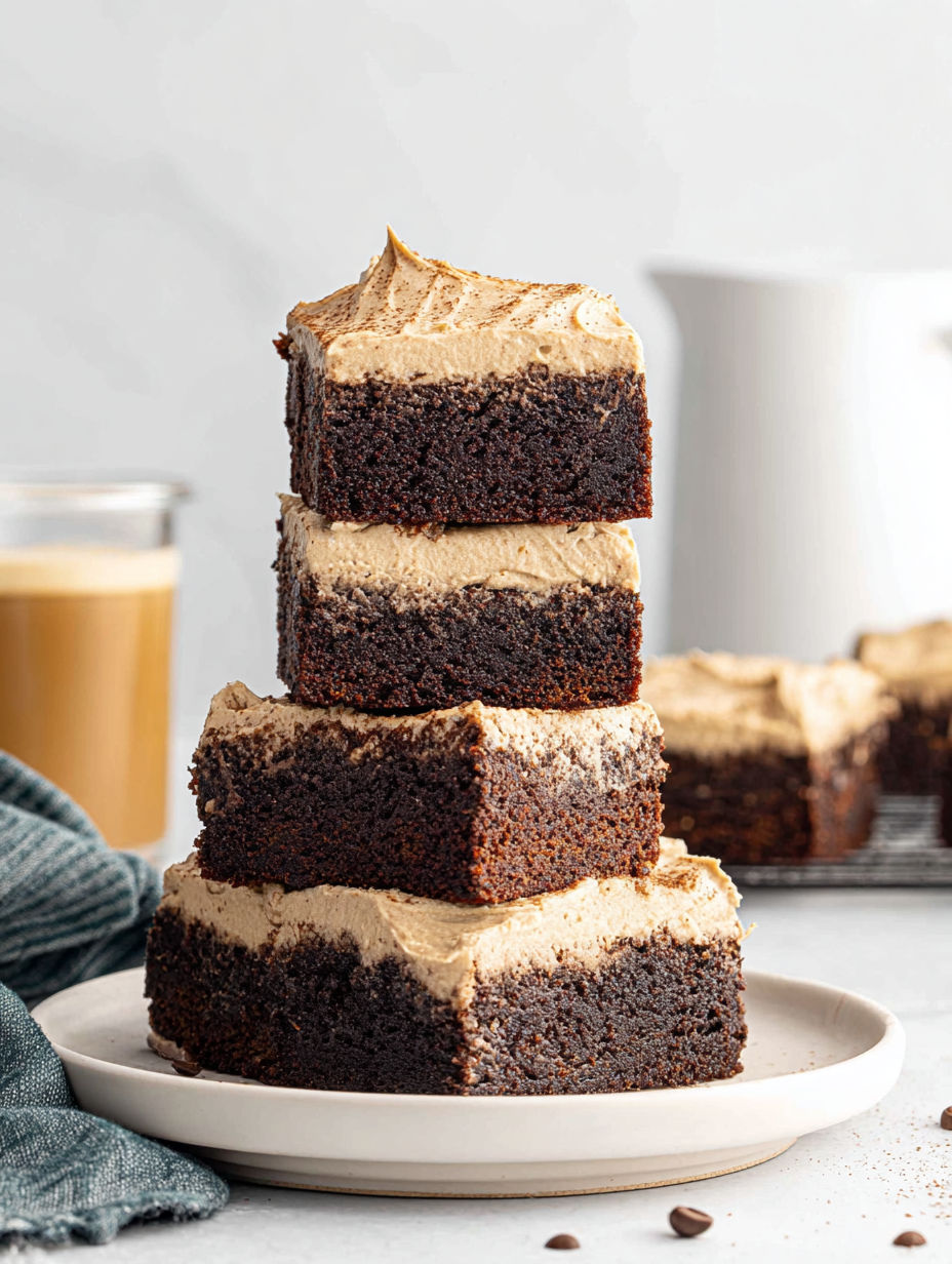 Three stacked brownies with a cup of coffee.