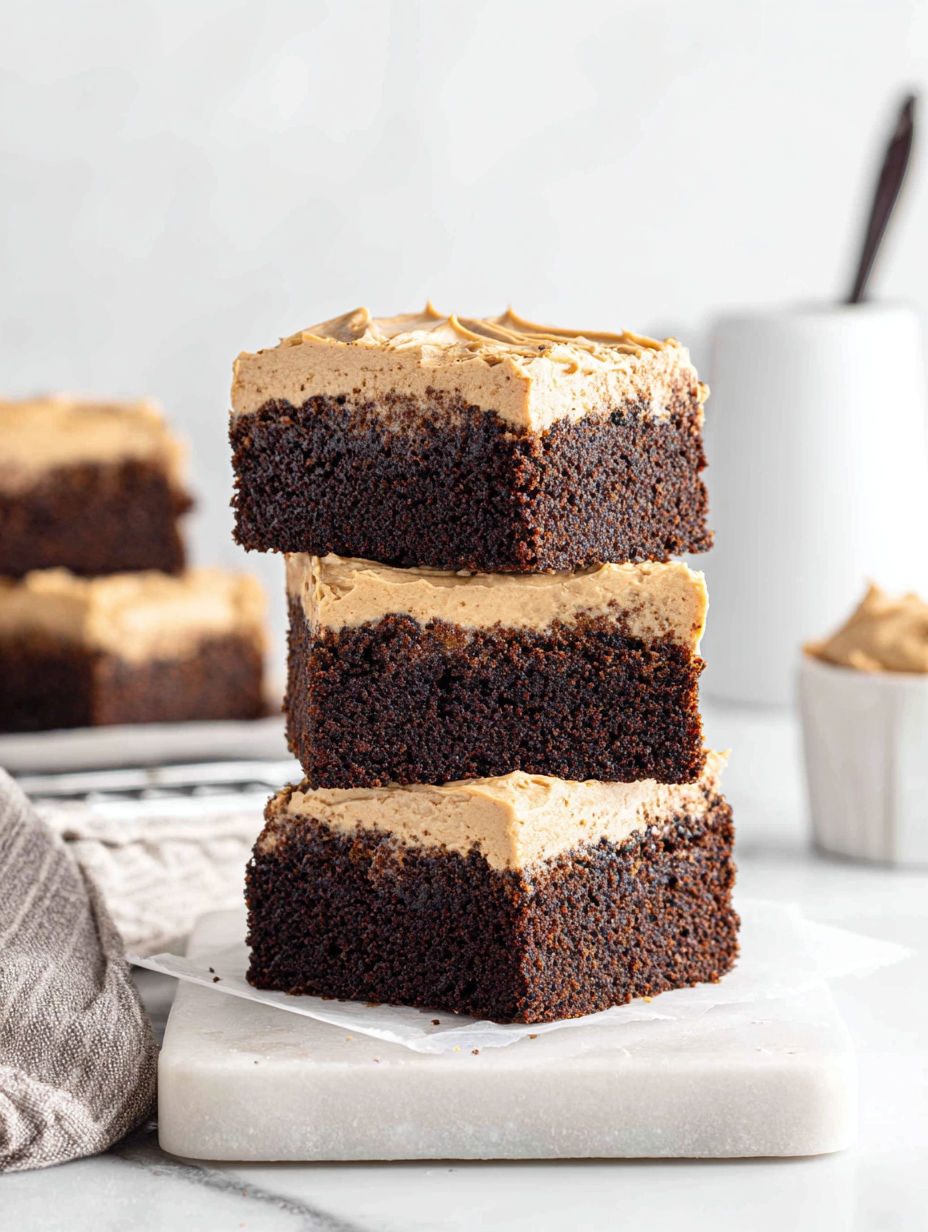 Three layers of mocha brownies stacked on a plate.