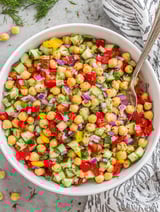 A bowl of chickpea salad with various vegetables.
