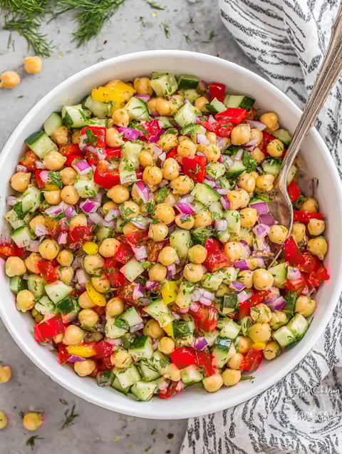 A bowl of chickpea salad with various vegetables.