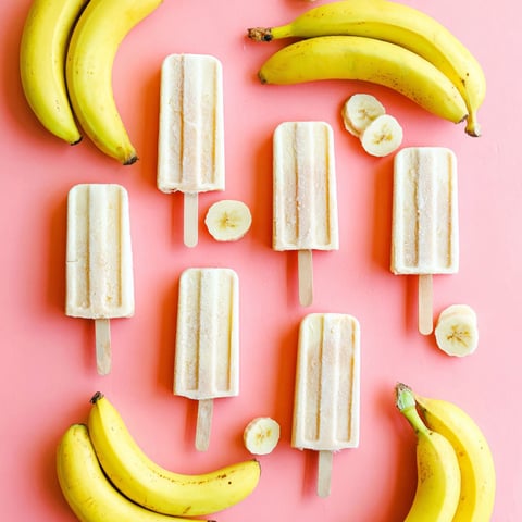 Banana popsicles with banana slices and a banana on the side.