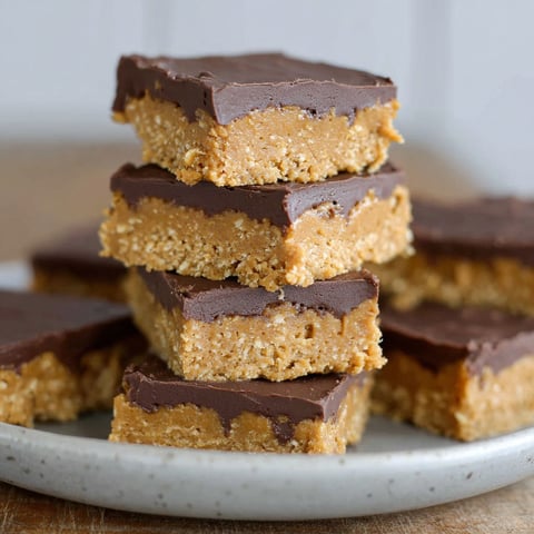 A stack of chocolate peanut butter bars with oats.