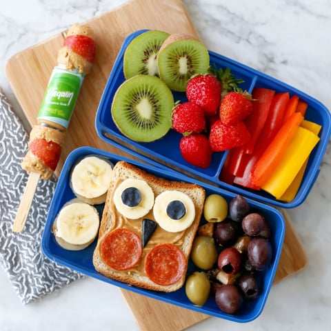 A fun lunch idea for kids includes a banana, kiwi, strawberries, and carrots.