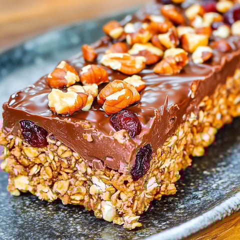 A close up of a granola bar with nuts and berries.