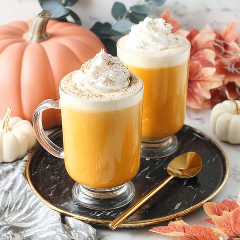Two cups of pumpkin spice milk with whipped cream.