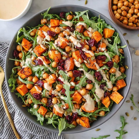 A bowl of roasted chickpea and sweet potato salad with sweet tahini dressing.