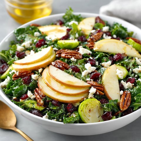 A bowl of salad with apples, pears, and honey dressing.