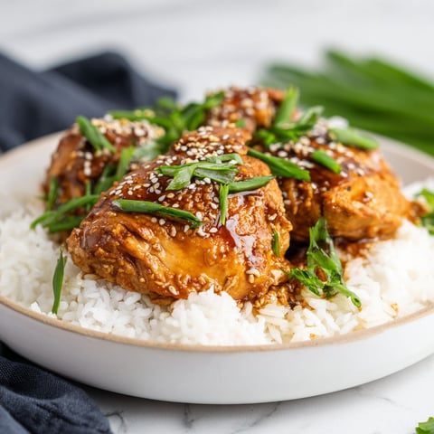 A plate of chicken with rice and sauce.