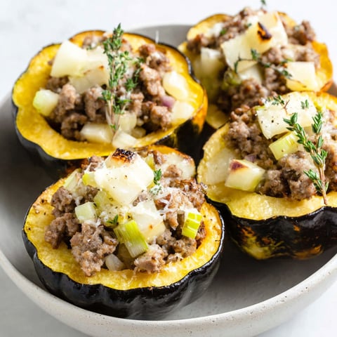A plate of stuffed acorn squash with sausage and cheese.