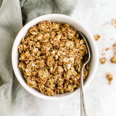 A bowl of granola with a spoon in it.