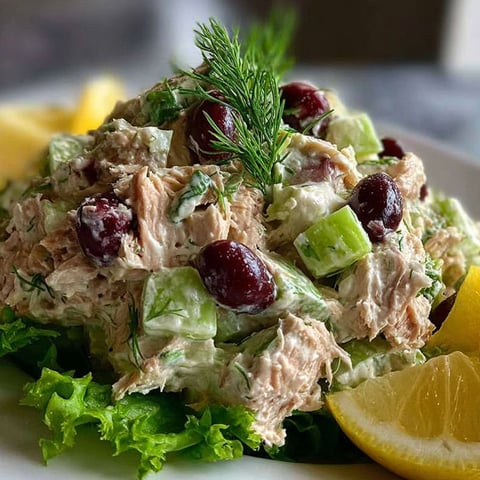 A plate of Greek yogurt tuna salad with a lemon wedge on the side.