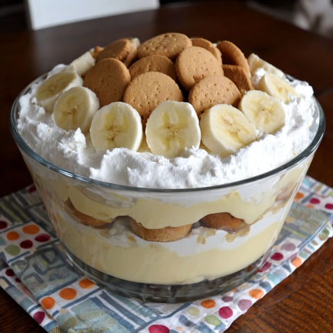 A large bowl of banana pudding with cookies on top.