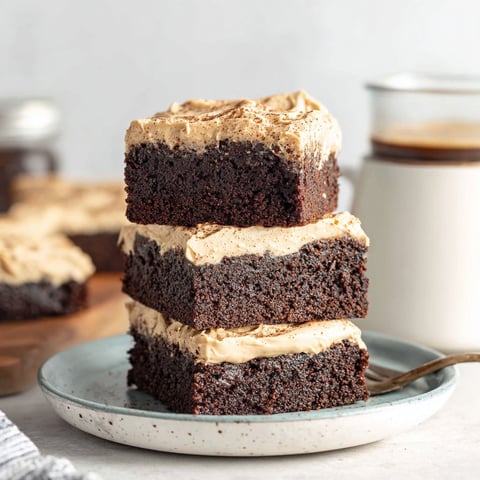 Three layers of mocha brownies stacked on a plate.